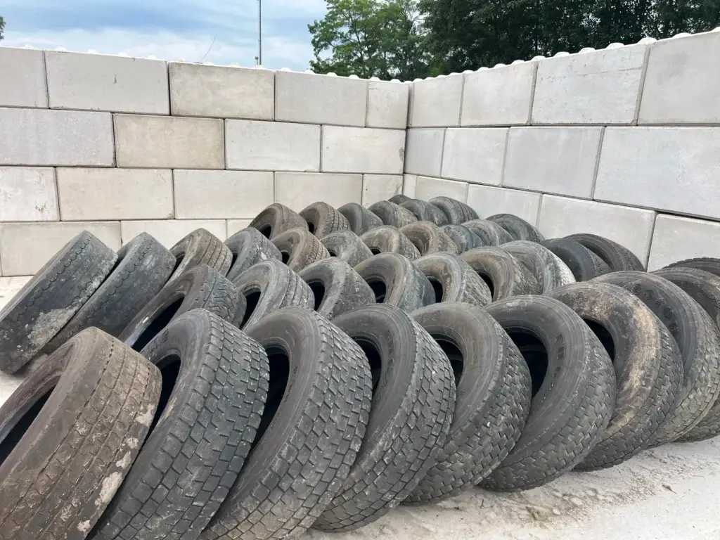 Gesammelte Altreifen in Betonbox zur fachgerechten Entsorgung und nachhaltigen Weiterverwertung im Reifenhandel