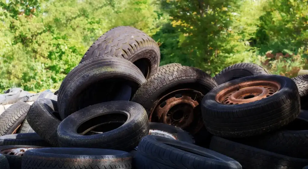 Haufen gebrauchter Altreifen mit Stahlfelgen zur fachgerechten Entsorgung und nachhaltigen Reifenverwertung